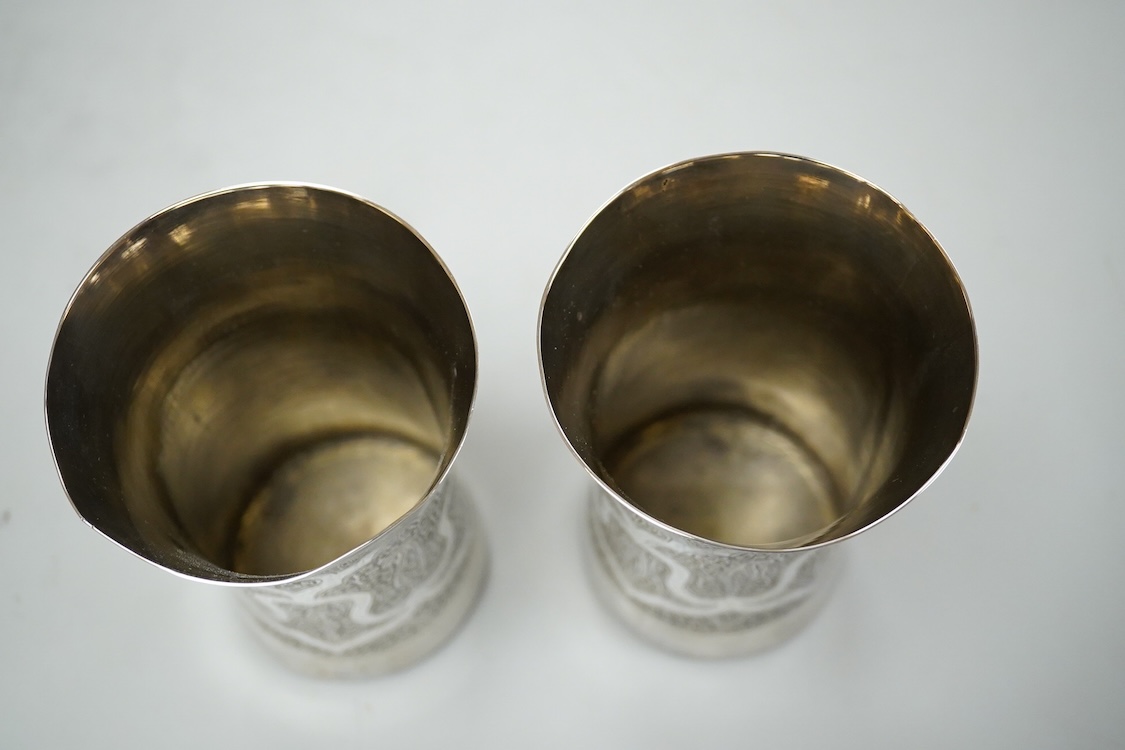 A pair of late 19th century Kashmiri white metal chased waisted beakers, height 12.4cm.